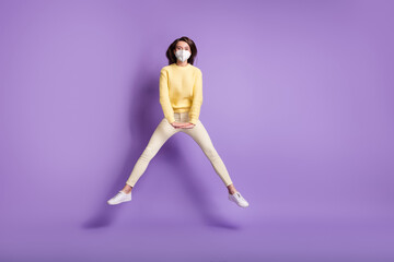 Fototapeta na wymiar Full body photo of girl jumping up spread legs hands wear respirator mask isolated on purple colored background