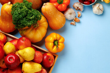Pumpkins, apples and bell pepper composition on blue background