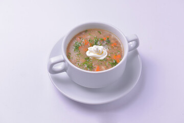 Creme soup with mushrooms in white bowl served over white background. Delicious vegetable soup for dinner.
