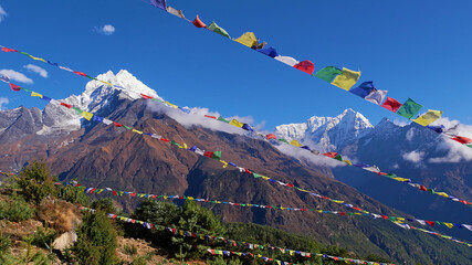 Several lines of colorful Buddhist prayer flags flying in the wind above Namche Bazar, Khumbu,...