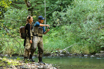 Young woman learning to fly fishing with a profesional guide