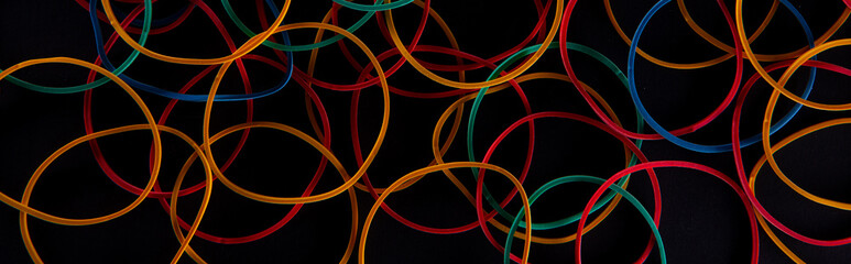 bright colorful stationery rubber bands on black background, close view . High quality photo