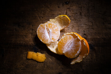 half open clementine with peels on wooden background