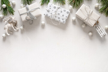 Christmas white gifts, sleigh, reindeer, evergreen branches on white. Xmas greeting card. Flat lay.