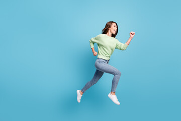 Full length body size side profile photo of pretty young girl running forward fast jumping smiling smiling isolated on vibrant blue color background