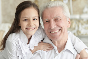 Portrait of happy elderly man with cute granddaughter