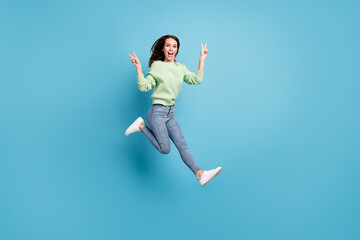 Fototapeta na wymiar Full length body size side profile photo of pretty young female student demonstrating v-sign gesture with both hands jumping up smiling isolated on vibrant blue color background