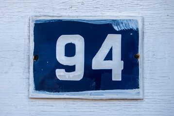 Weathered grunge square metal enameled plate of number of street address with number 98