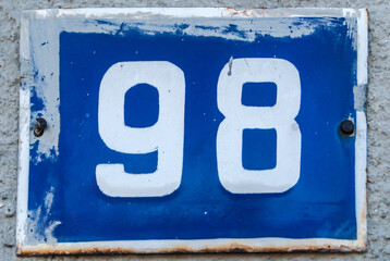 Weathered grunge square metal enameled plate of number of street address with number 98
