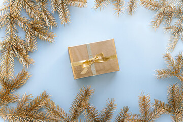 Blue Christmas or new year's background,plain composition of golden Christmas gifts and golden fir branches, Flatlay,empty space for greeting text.christmas concept.