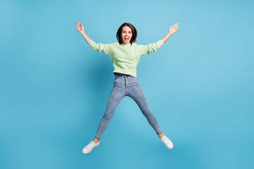 Fototapeta na wymiar Full length body size photo of funny jumping high like a star girl wearing casual clothes laughing smiling isolated on vibrant blue color background