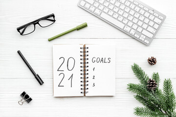 New year goals list. Christmas decorations and notebook on a table, flat lay