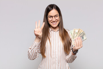 pretty woman  smiling and looking friendly, showing number three or third with hand forward,...