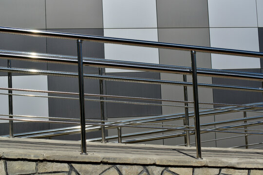 steel handrails at the wheelchair ramp against the background of the building wall