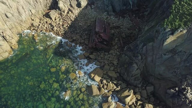 Old RMS Mulheim Shipwreck Lying On The Rocks At The Coast Between Land's End And Sennen Cove In Cornwall, UK - top-down drone