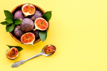 Fresh figs in a bowl with green leaves. Top view