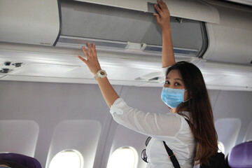 Asian woman tourist on airplane,  medical protective sterile mask on his face traveling. Pandemic covid-19. Safety in public transport.Coronavirus flu virus travel concept
