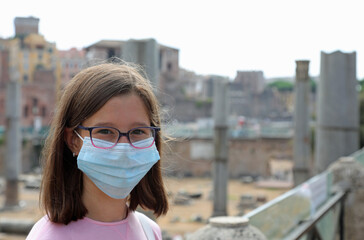 young girl with surgical mask while visiting the city of Rome in