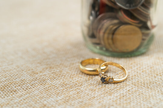 wedding rings with Coins in jar, saving money for marry.