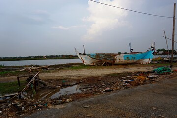 A broken boat parked on the beach under the blue sky adds to the beauty of the beach, Lebak beach, Jepara. Indonesia