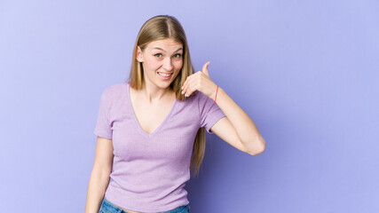 Obraz na płótnie Canvas Young blonde woman isolated on purple background laughing about something, covering mouth with hands.