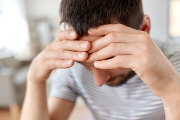 stress, failure and people concept - close up of stressed young man having headache at home