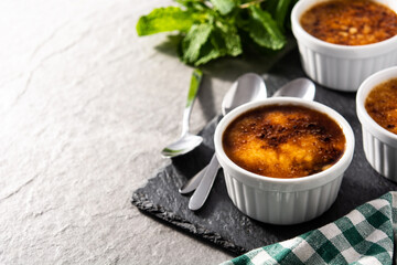 Homemade creme brulee on gray stone. Copy space