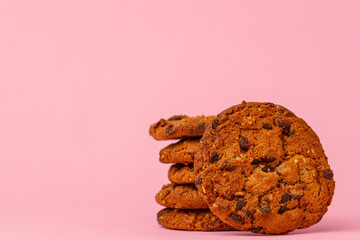 Stacked chocolate chip cookies against pink background