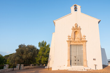 Ermita de Sant Benet i Santa Llucia, Alcossebre (Alcala de Xivert), Catalunya, Spain. Beautiful white chapel on top of a mountain. Valencian baroque architecture. Blue sky.