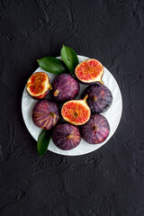 Fresh figs in on a plate with green leaves. Top view