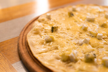 Four cheese pizza. Pizza stuffed with four varieties of cheese on a gray background.