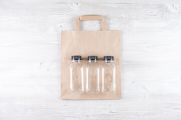 mockup, scene creator. paper bag, three plastic bottles. Eco-friendly food packaging and cotton eco bags on gray background with copy space. containers for catering and street fast food.