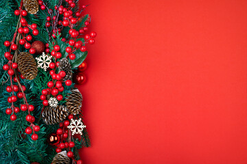 Naklejka premium Christmas decorations on the red background. Top view with copy space for your text.