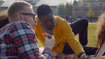 Couple of diverse gays having fun in park with adopted little daughters