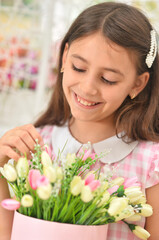 Happy little girl posing with tulips on swing