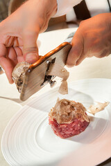 Alba white truffle sliced by the waiter's hands on raw minced meat from Piedmontese beef of the Fassona breed