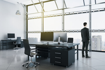 Businessman in suit standing in contemporary coworking office interior