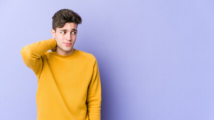 Young caucasian man isolated on purple background touching back of head, thinking and making a choice.