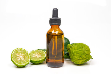 Bergamot oil in bottle and fresh bergamot fruit with green leaf isolated on white background.
