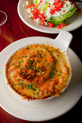 Steakhouse side dishes. Asparagus, salad, tomatoes, mashed potatoes, red onions, cream cauliflower, pickled peppers, seasoned meats served in cast iron skillet. Traditional appetizer items.