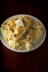 Steakhouse side dishes. Asparagus, salad, tomatoes, mashed potatoes, red onions, cream cauliflower, pickled peppers, seasoned meats served in cast iron skillet. Traditional appetizer items.