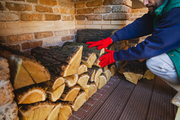 Gloved hands lay wooden log in niche