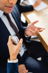 cropped view of correspondent with dictaphone interviewing indian politician gesturing during press...