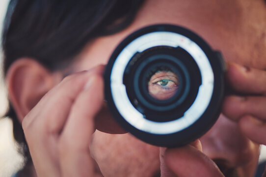 Closeup Shot Of A Person Looking Through A Camera Lens