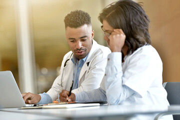 Young doctors working on laptop at the hospital