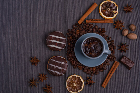 A cup of espresso is decorated with anise stars, cinnamon, sweets, dried lemons, acorns, peanuts in a beautiful dish. © reme80