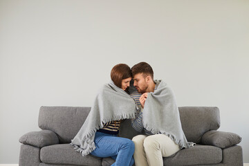 Freezing couple in cool room cuddling in plaid