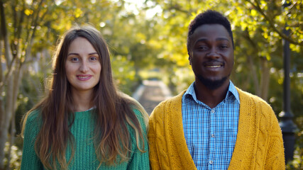 Portrait of romantic and mixed race young couple standing in park