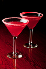 Cosmopolitan Cocktail. Action shot. Alcoholic Drinks made with gin, vodka, rum or whiskey mixed with soda water, fruit juices and garnishes with limes and cherries. Classic American bar drinks.