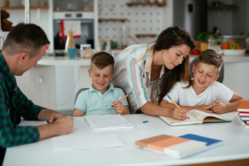 Parents helping the kids with their homework. Litlle boys learning at home..
